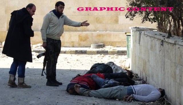 Militants gesture next to the bodies of handcuffed and blindfolded dead men laying on the ground of the Aleppo headquarters of the Islamic State of Iraq and the Levant (ISIL) after they were allegedly executed by the al-Qaeda-linked group, in the northern city of Aleppo, on January 8, 2014 
